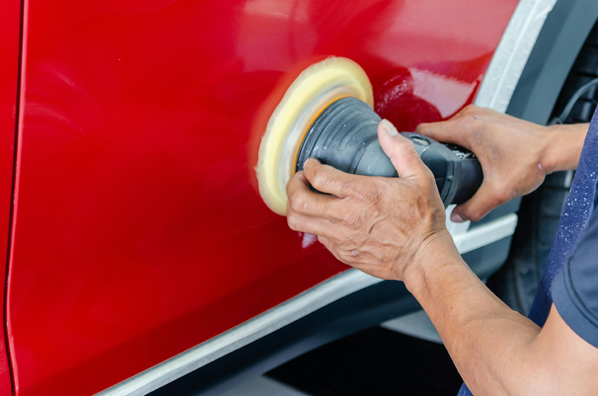 person buffs the side of a car