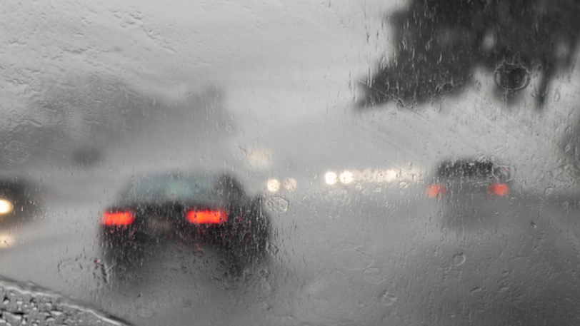 A view from inside a car driving on the highway in heavy rain and fog.